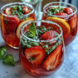 Crimson red strawberry basil lemonade refreshment ready for summer party guests.