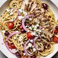 Juicy grilled chicken, briny Kalamata olives, and creamy feta cheese tossed with al dente spaghetti in this vibrant Greek Chicken Spaghetti.  