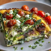Healthy Easy Spring Veggie Frittata with asparagus, spinach, and feta cheese, golden and fluffy, served hot from the oven.